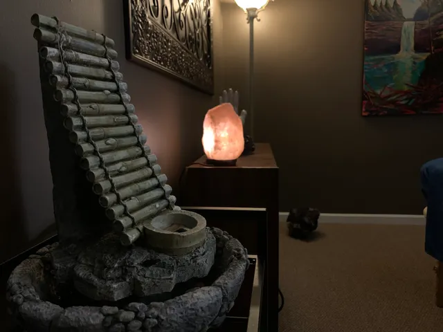 Salt-lamp glow and a stone fountain in the treatment room